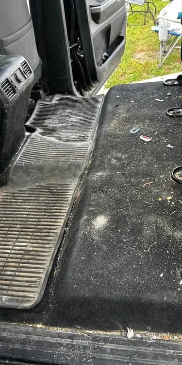 Pickup truck rear carpet and floor mat with embedded debris before detailing